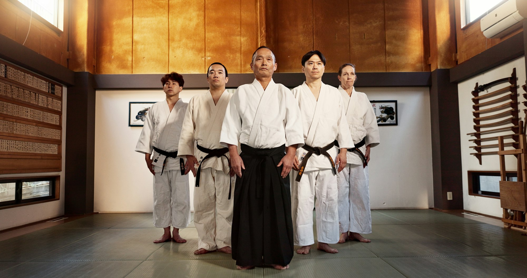 Black belt students, bow or sensei in dojo for aikido practice, discipline or self defense. Combat