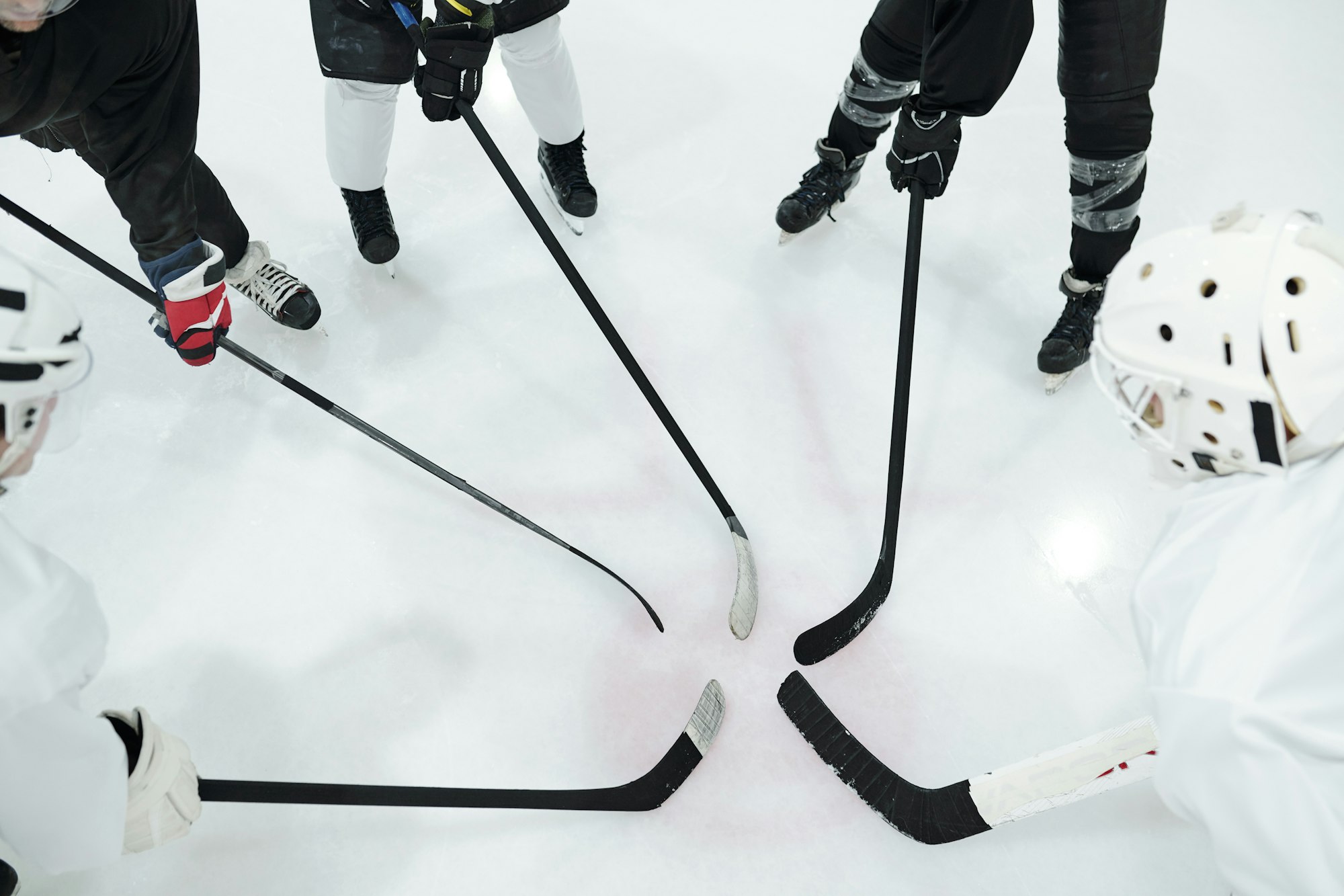 Group of hockey players in sports uniform, gloves and skates standing in circle