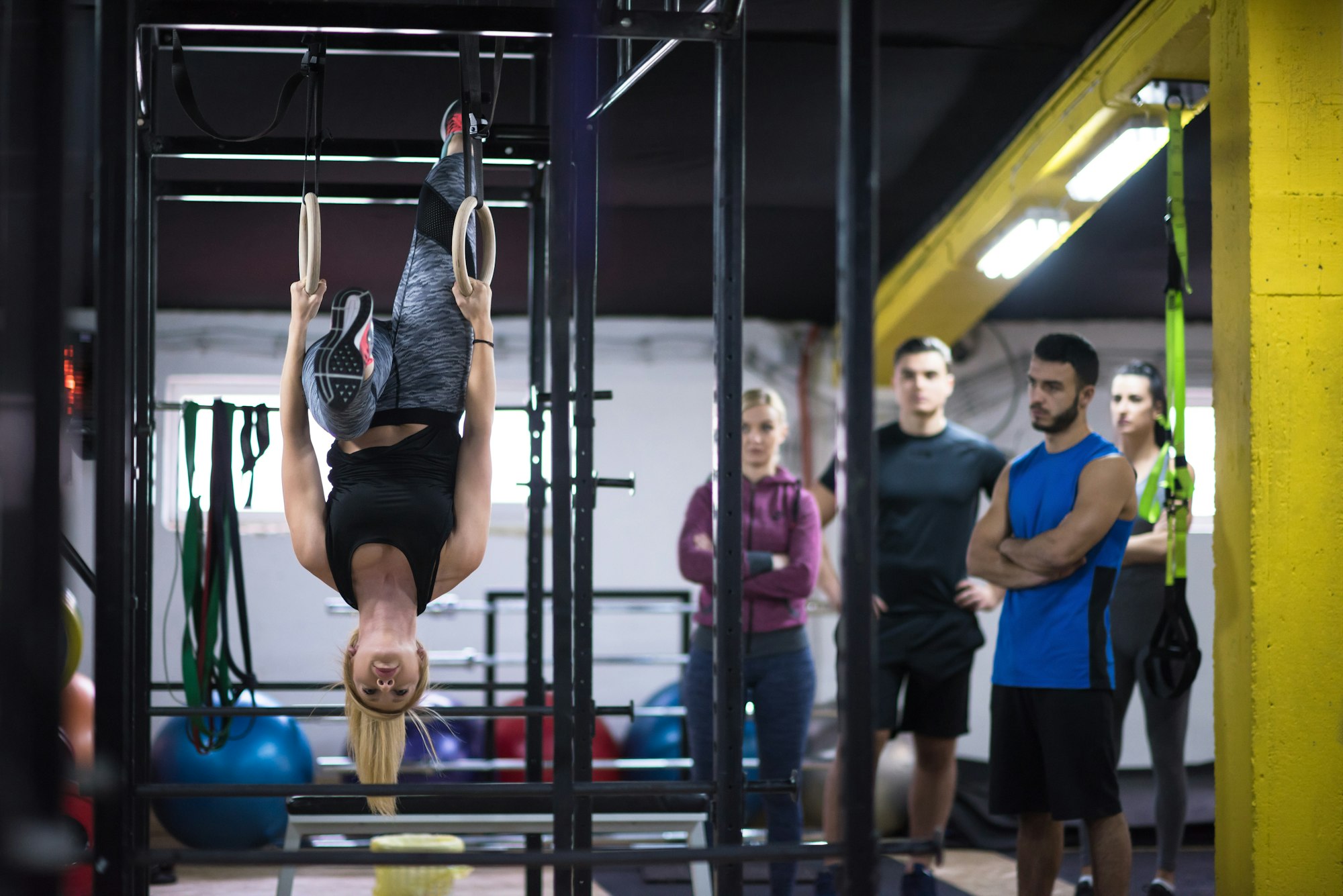 woman working out with personal trainer on gymnastic rings